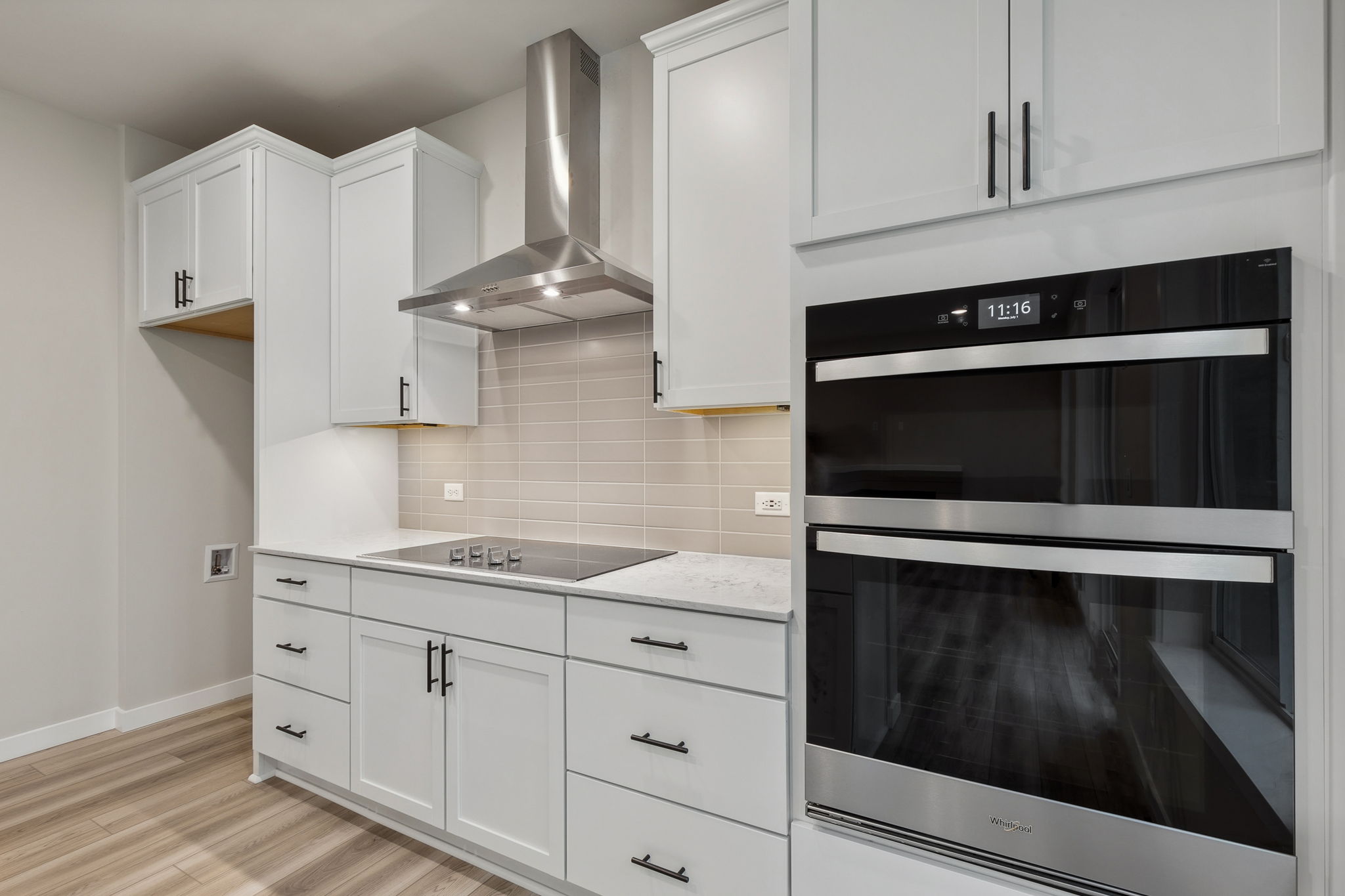 A kitchen with white cabinets.