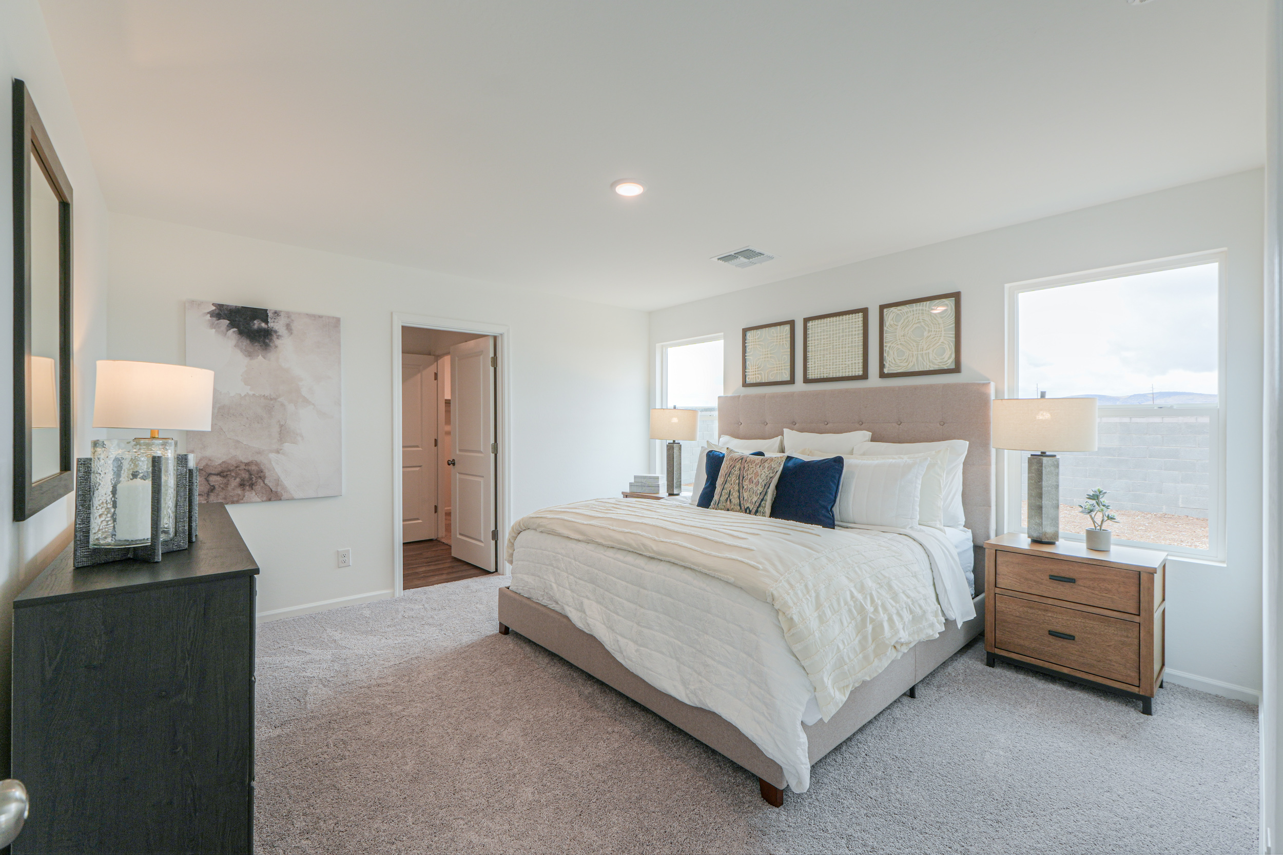 A bedroom with a bed and lamps.