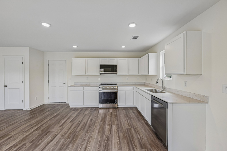 A kitchen with white cabinets.