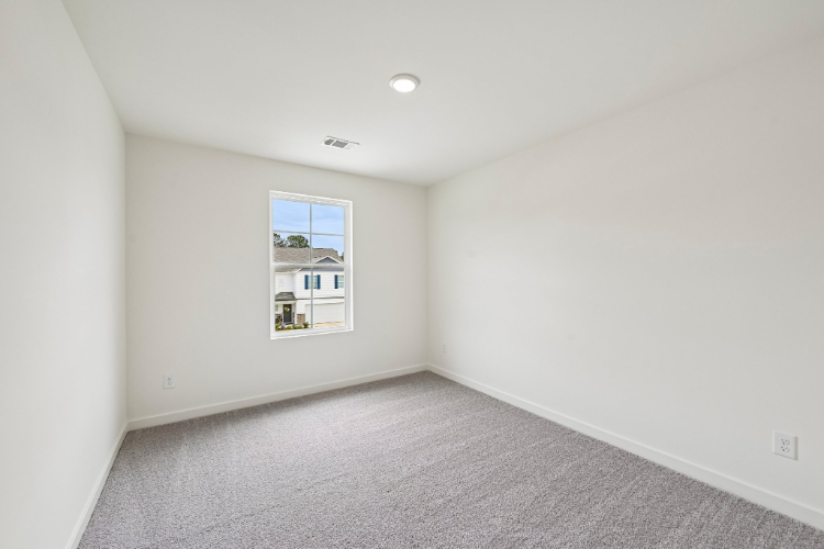 A room with a window and a carpet.