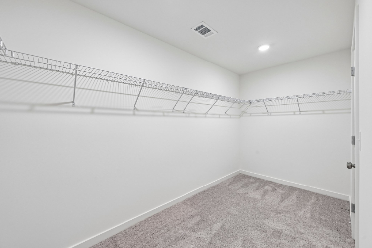 A white hallway with a metal railing.