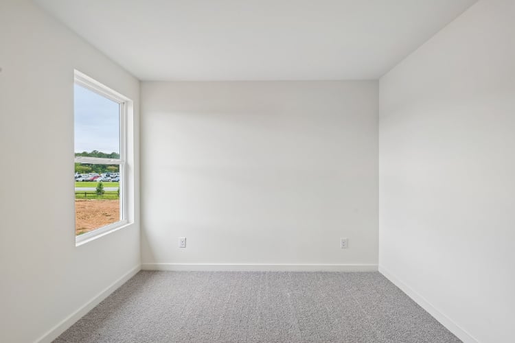 A room with a window and a carpet.