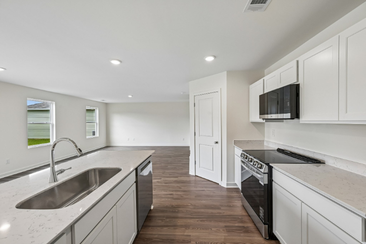 A kitchen with white cabinets.