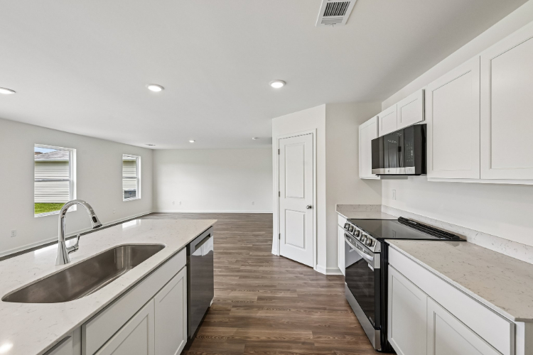 A kitchen with white cabinets.