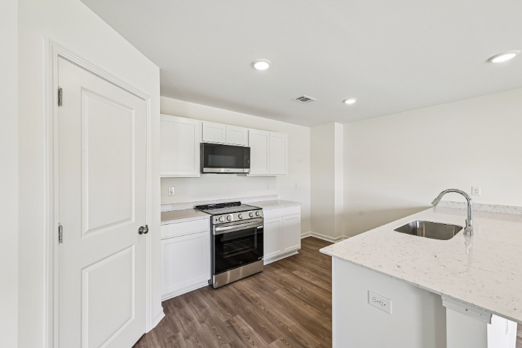 A kitchen with white cabinets.