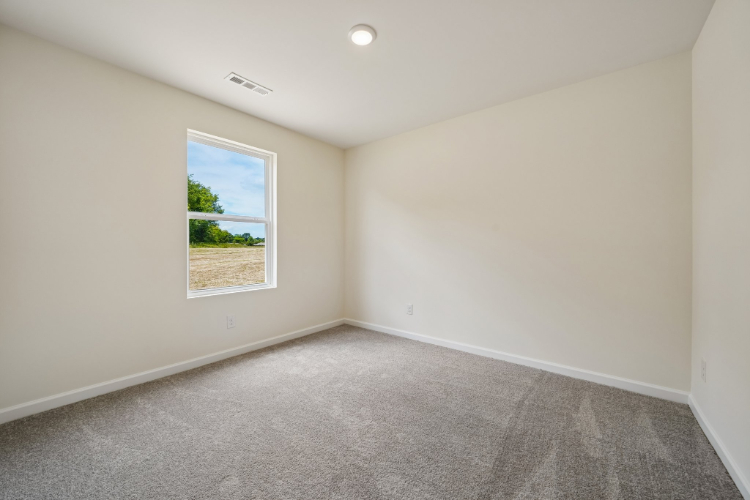 A room with a window and carpet.
