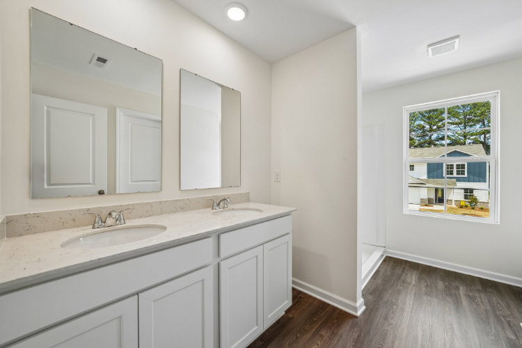 A bathroom with white cabinets.