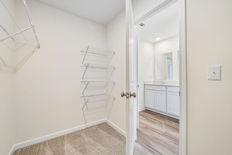 A white room with a white door and a white shelf.