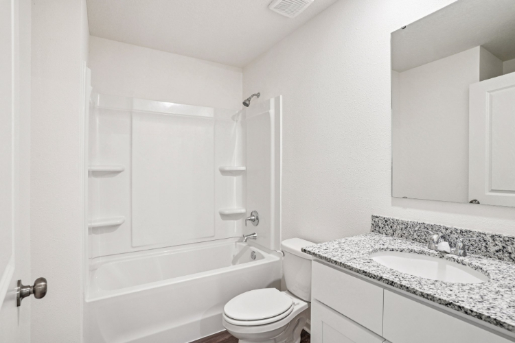 A bathroom with a tub sink and toilet.
