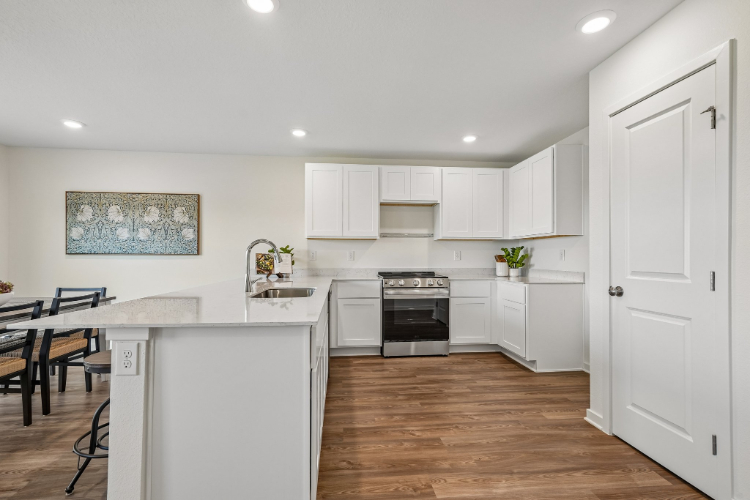 A kitchen with white cabinets.
