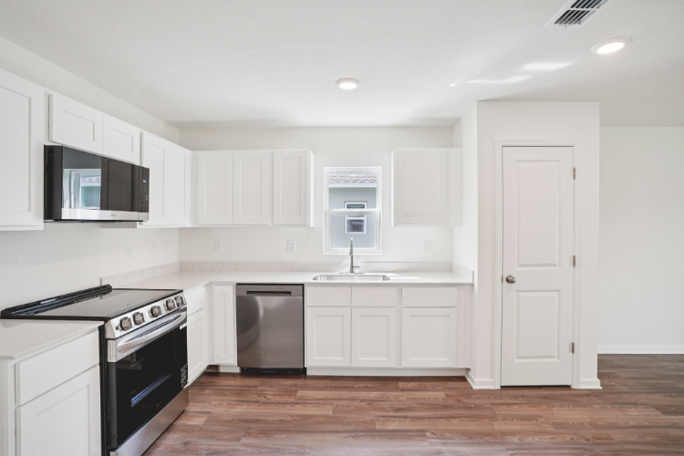 A kitchen with white cabinets.