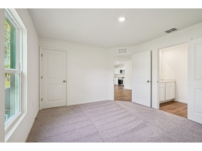 A long hallway with white doors.