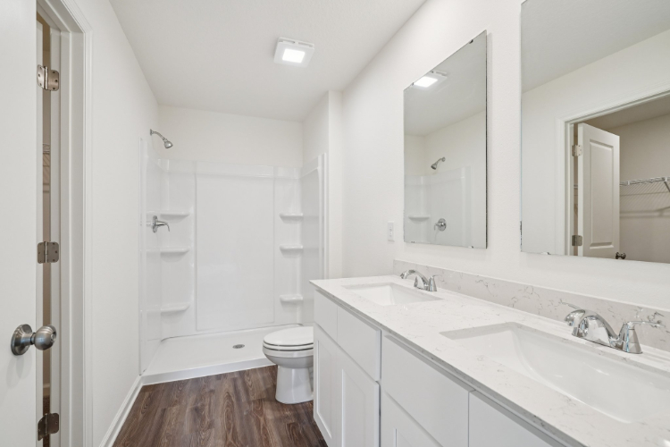 A bathroom with a sink toilet and mirror.