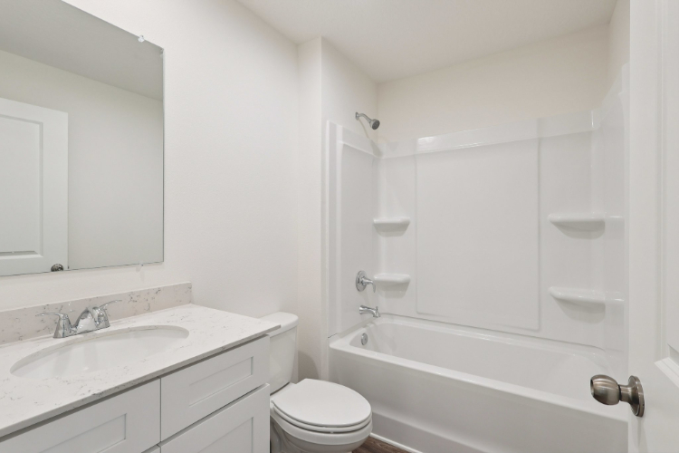 A bathroom with a tub sink and toilet.