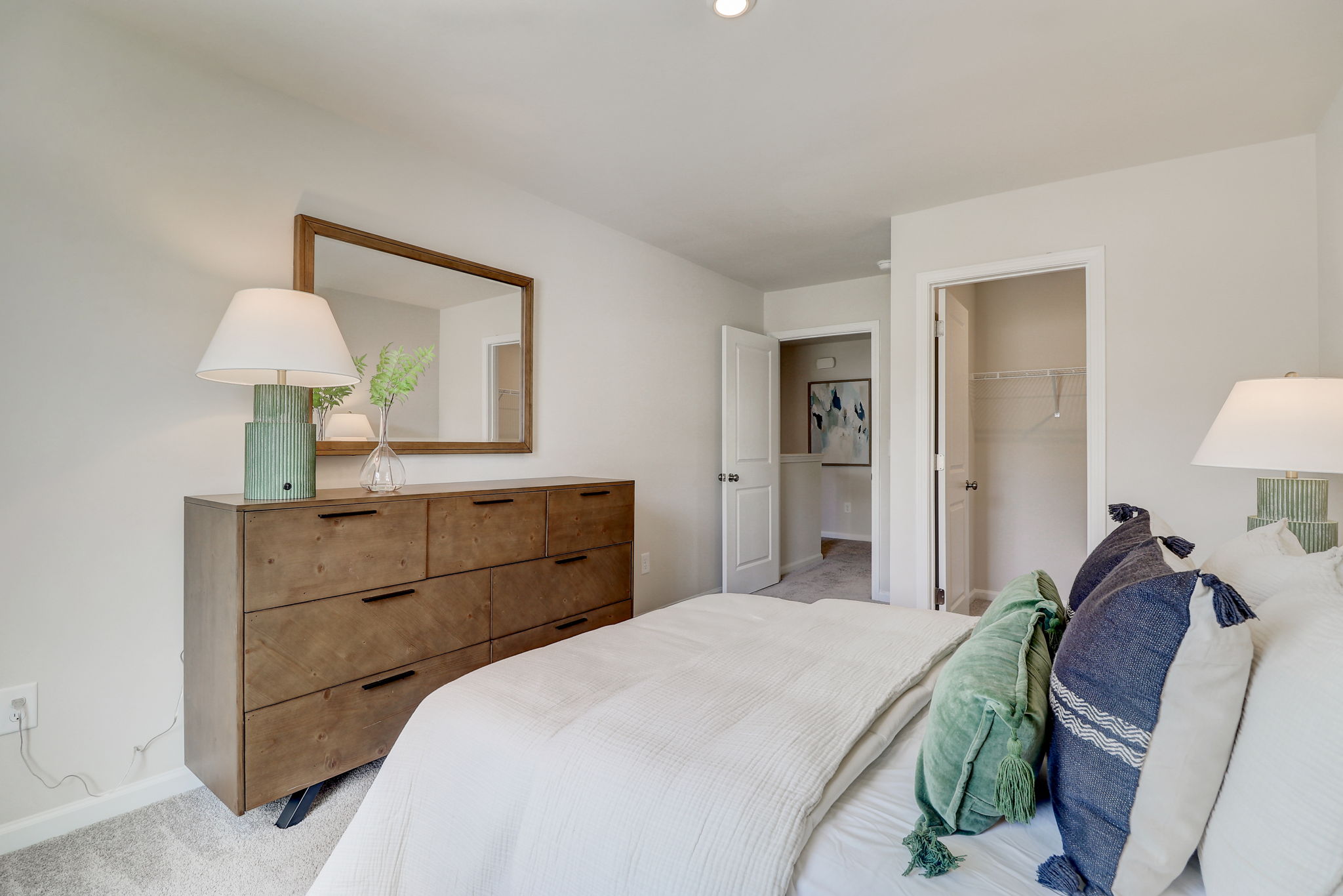 A bedroom with a bed and a dresser.