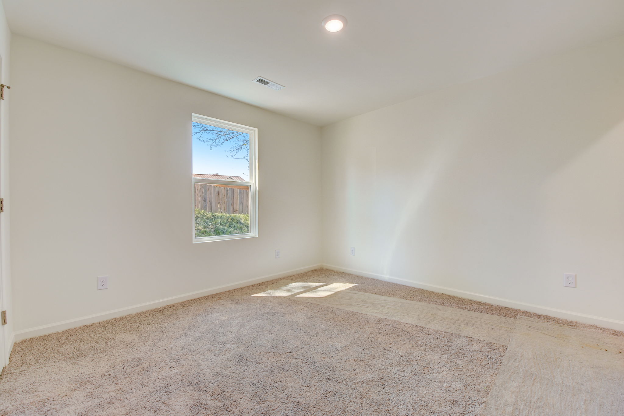 A room with a window and carpet.